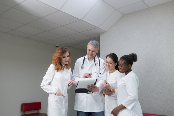 一群医务人员在诊所的走廊上讨论诊断结果。医护人员在医院走廊上讨论病人的治疗问题图片下载