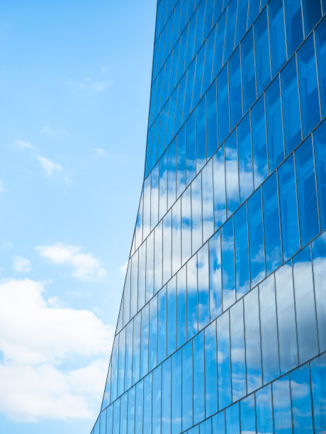 白云映照在现代办公大楼的玻璃窗上。图片下载