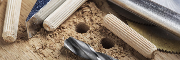 钻头在橡木木板上钻孔，用于木销子。图片下载