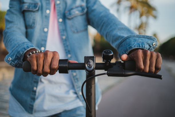手持电动滑板车把手的男子图片下载