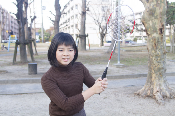 十几岁的女孩有羽毛球拍和玩图片下载