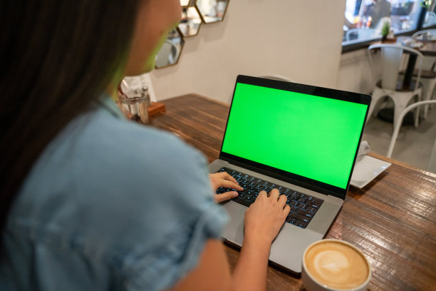 一个女人在咖啡馆检查她的电脑图片下载