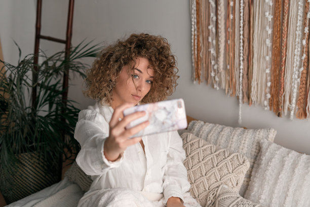 年轻女子用智能手机自拍图片下载