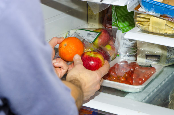 手在橘子和苹果之间选择图片下载