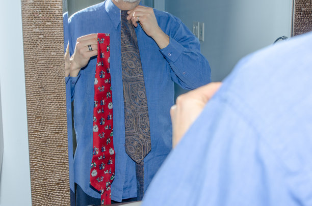 男人在镜子前选择领带图片下载