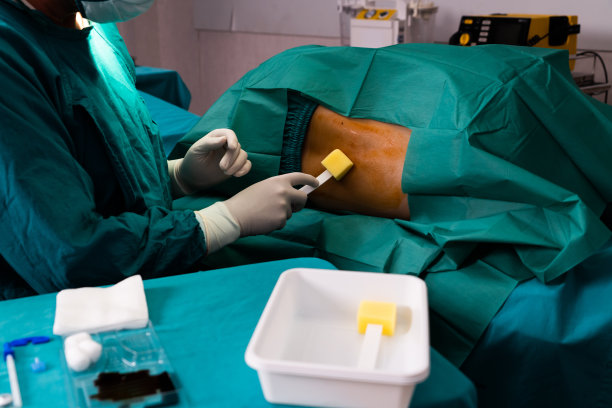 医生或外科医生在无菌手术室给病人使用碘碘。图片下载