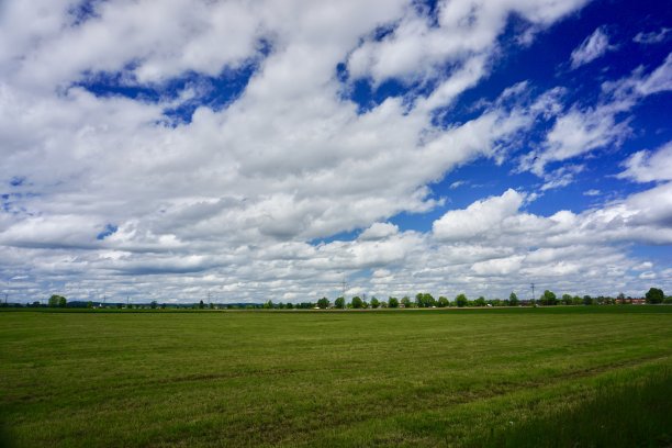 巴伐利亚的典型景象:群山、田野、草地和云雾缭绕的天空。在巴伐利亚的田野、草地和山上有许多美丽的云。上巴伐利亚春季的自然风光。巴伐利亚春季田野的全景。图片下载