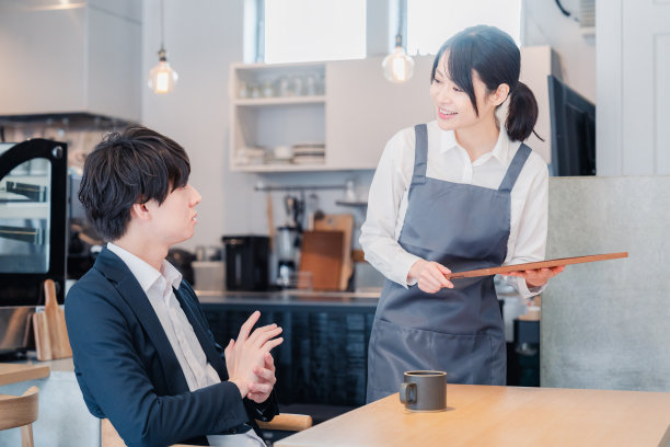 Staff talking with a male customer at a café图片下载
