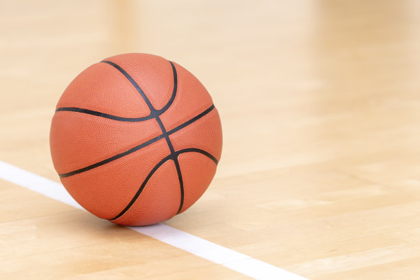 硬木球场地板上的橙色篮球。水平运动主题海报，贺卡，标题，网站和应用程序图片下载