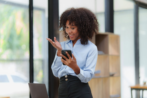 商业黑人妇女正在办公室与客户电话交谈。非裔美国年轻女子使用智能手机图片下载