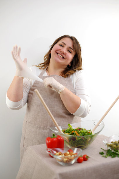 美丽丰满的女人烹饪食物的概念清洁整洁健康的态度食材是在桌子上的木勺在玻璃碗将揉沙拉真诚微笑的地方为文图片下载