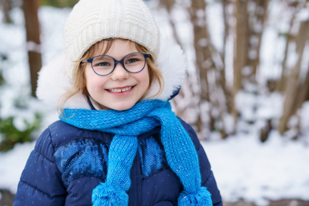 戴眼镜的可爱学前班女孩。可爱的健康快乐的孩子玩和玩雪，在寒冷的日子户外。冬季与孩子们一起积极休闲图片下载