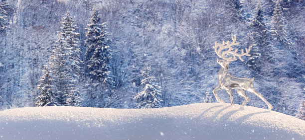 圣诞冬天的背景与落下的雪，旗帜的观点冰鹿在雪堆对山区森林的背景图片下载
