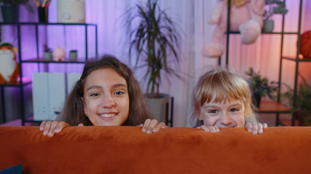 笑眯眯的姐弟姐弟姐们玩着捉迷藏的躲猫猫游戏，在家里恶作剧图片下载