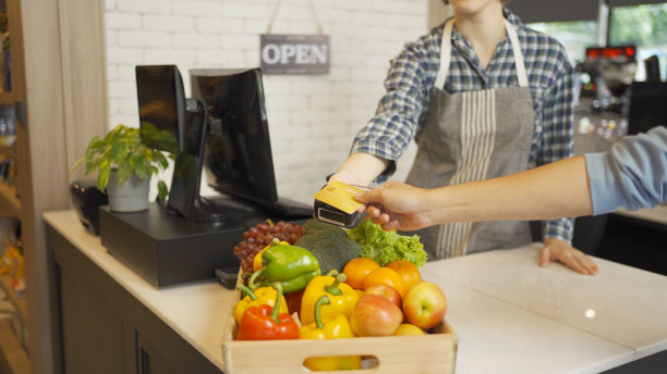 人们在超市或零售商店购物，在食品杂货货架的收银台用手机用在线信用卡购买零食和食品。购买食物。人们的生活方式。结账服务图片下载