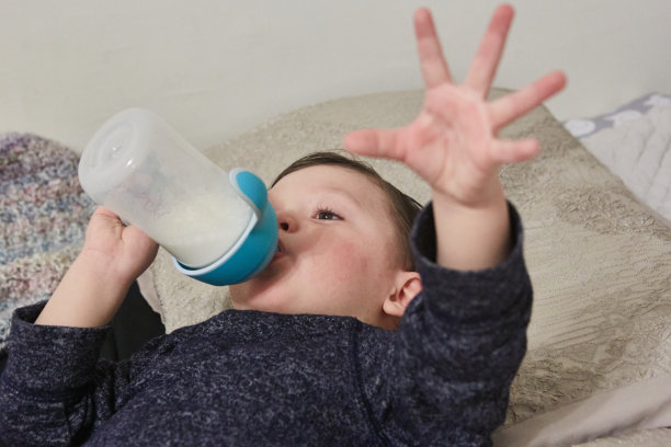 幼儿用奶瓶喝牛奶图片下载