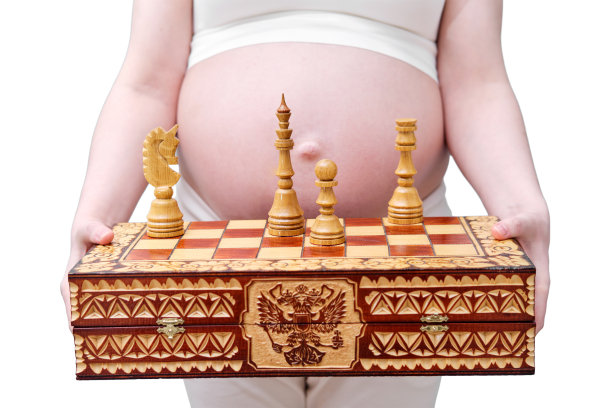 孕妇手中的国际象棋，摄影棚拍摄，孤立在白色背景上图片下载