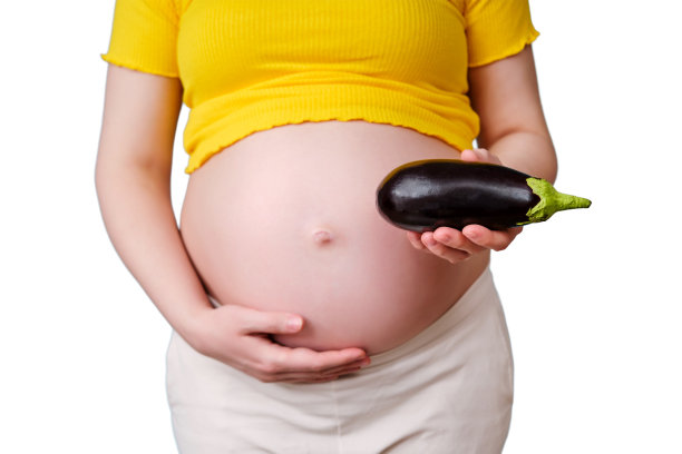 一名孕妇手中的茄子蔬菜，孤立在白色背景上图片下载