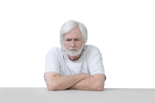 愤怒的老人双手交叉坐在白色的椅子上图片下载