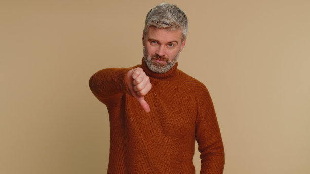 心烦意乱的高级男子男子在毛衣显示拇指向下手势，不赞成，不满不喜欢图片下载