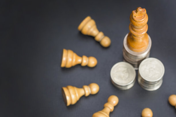 木棋白色的国王在成堆的金币和分散的兵在黑色黑暗的背景。金钱、领导力、成功、财富、人事管理的概念图片下载