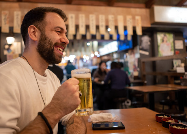 外国游客在日本居酒屋酒吧喝啤酒图片下载