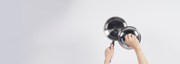 清洁锅的人在白色的背景上用方便的洗碗海绵清洁不粘锅，软的一面是黄色，硬的一面是绿色，以保证烹饪后的卫生。电锅图片下载