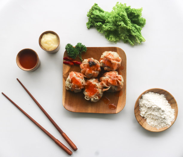 蒸饺配蛋黄酱和辣椒酱，放在棕色盘子里。白色背景。孤立的图片下载