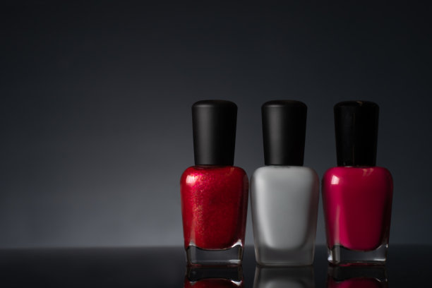 黑色背景上的彩色指甲油瓶子图片下载