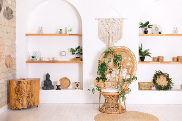 设计孔雀柳条椅和木制架子与装饰时尚的卧室内部。客厅白墙边的藤制孔雀扶手椅。侘寂室内部。生态自然家具。图片下载