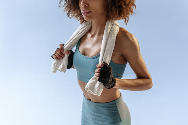 近距离运动的女人站在她的脖子上的毛巾工作室背景图片下载