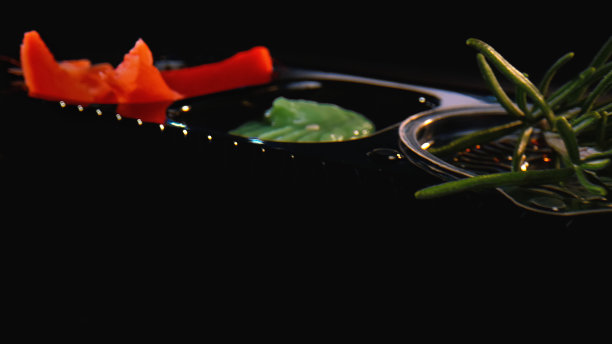 装有姜、山葵、树叶和酱油的黑色塑料容器图片下载