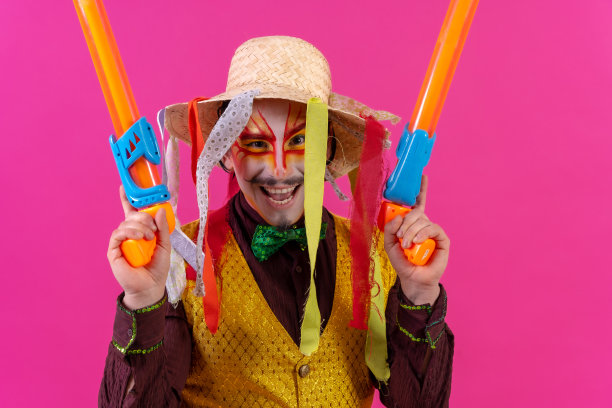 粉色背景上画着白色脸谱的小丑，拿着玩具枪和帽子图片下载