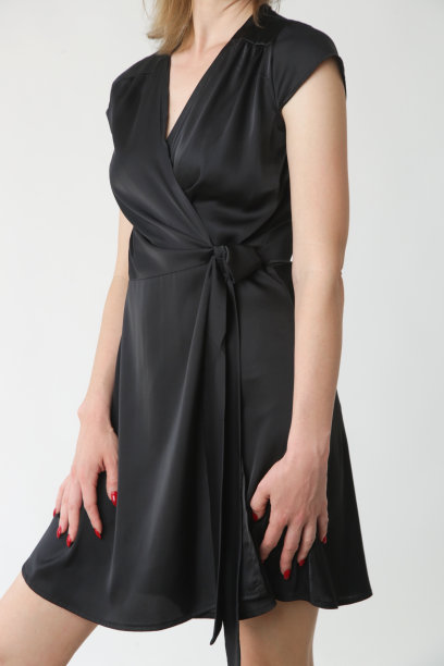 系列工作室的照片，年轻的女模特在黑色丝绸缎面包裹迷你连衣裙。图片下载