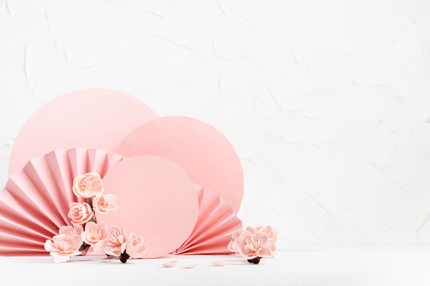 温柔的春天花卉背景在日本风格-粉红色的樱花，花瓣，粉红色的圆圈，纸扇在白色的桌子上作为舞台展示化妆品，商品，品牌，设计，卡片，海报。图片下载