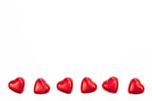 白色背景上的心形巧克力糖果，平铺。图片下载