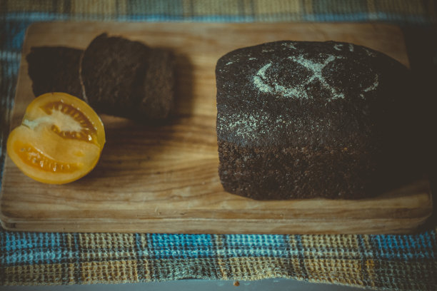 近自制黑麦面包和半个西红柿在砧板概念照片图片下载