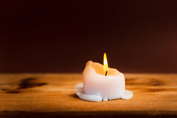 宗教的概念。在教堂的旧木制背景上点燃蜡烛。烛光在老式木桌基督教学习和阅读在家里。宗教的概念。深棕色背景。图片下载