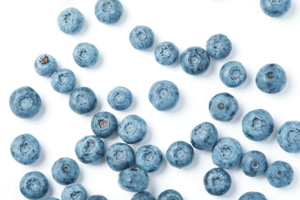 新鲜的蓝莓散落在白色的背景上。图片下载