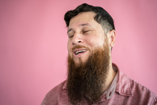 中年成年男子闭着眼睛在粉红色的背景上想象图片下载