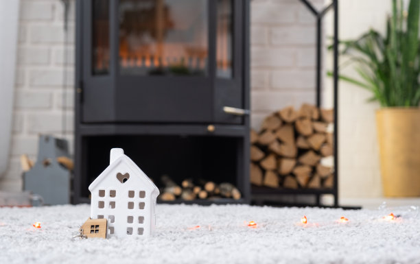 钥匙的房子与钥匙链对背景的壁炉火炉与火和柴火。舒适的家。建筑，设计，工程，搬新房，抵押，租赁和购买房地产图片下载