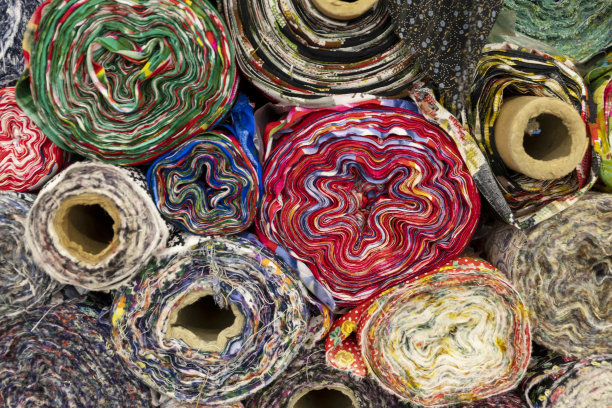 在纺织品市场上发现的不同颜色的布料和面料样品的详细特写视图。图片下载