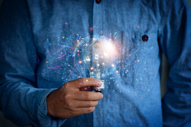 男人拿着灯泡，用创新的技术和创意想出新点子。创造力的概念图片下载