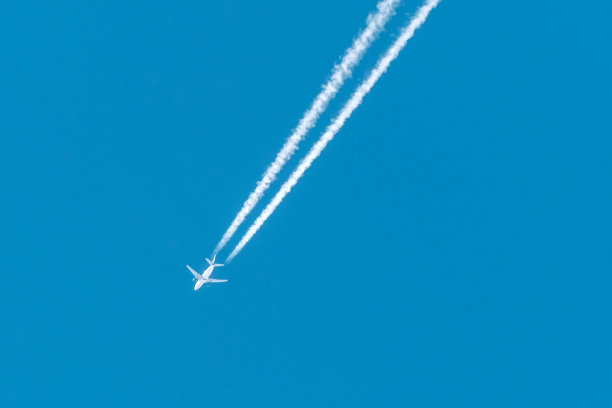 飞机在蓝天中飞行的照片和凝结的痕迹图片下载