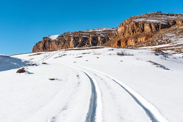 照片的汽车轨道上的雪地在高地图片下载