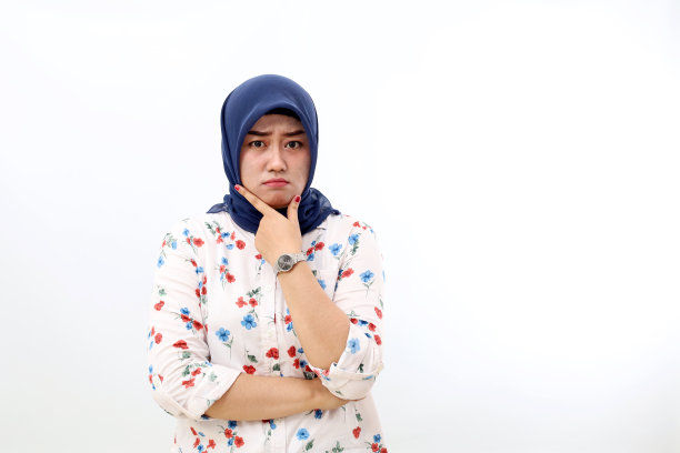 困惑的亚洲穆斯林妇女站在一边思考着什么。白色背景隔离图片下载