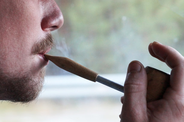 抽烟斗的年轻人，侧面特写图片下载