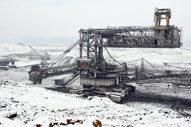 冬季条件下露天煤矿上的大型挖掘机。雪下采矿的有趣外观。图片下载