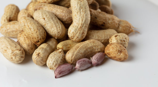 把煮好的花生堆成一堆，煮好的花生倒在地上。热带煮花生特写。白色背景隔离高速快门，冻结动作图片下载