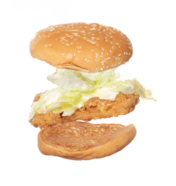 炸鸡汉堡炸飞了，炸鸡汉堡菜掉了。热面包，鸡肉，汉堡，快餐，在空气中飞溅。白色背景隔离高速快门，冻结动作图片下载